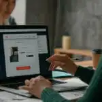 รับออกแบบเว็บไซต์ ทีมงานออกแบบเว็บไซต์กำลังทำงานบนแล็ปท็อป เลือก "SHOP NOW