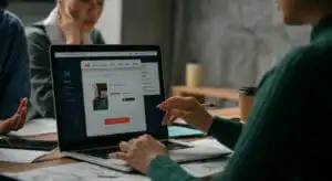 รับออกแบบเว็บไซต์ ทีมงานออกแบบเว็บไซต์กำลังทำงานบนแล็ปท็อป เลือก "SHOP NOW