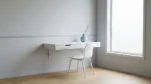 รับออกแบบเว็บไซต์ โต๊ะทำงานติดผนังสีขาวสไตล์มินิมอล พร้อมเก้าอี้สีขาวและแจกันสีฟ้า